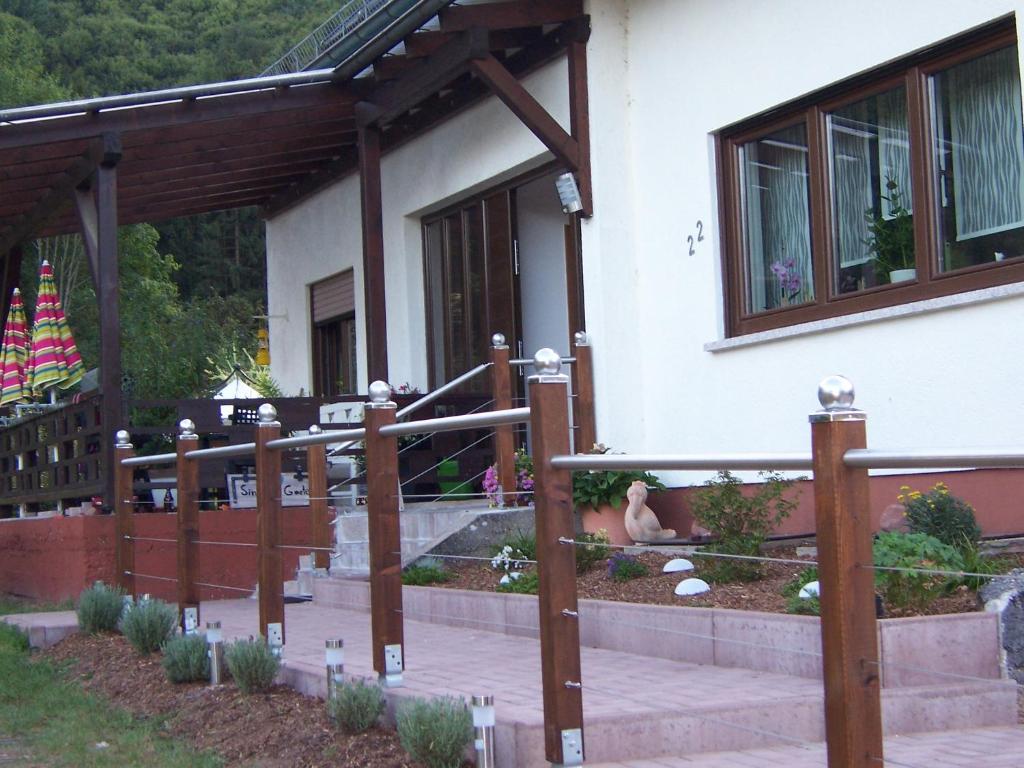 a house with a wooden fence and a patio at Ferienwohnung am Pfaffenfels in Schönau