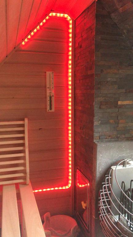 Zimmer mit einer Sauna mit rotem Licht in der Unterkunft Lütt Reethuus in Fehmarn