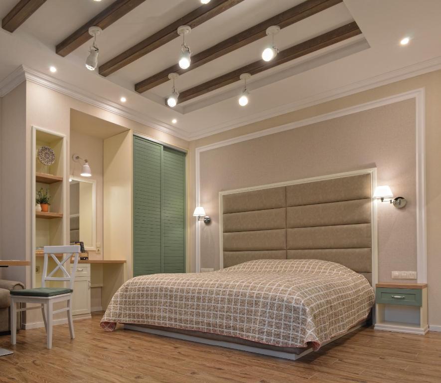 a bedroom with a bed with a large headboard at Divona Studio 2 in Ruse