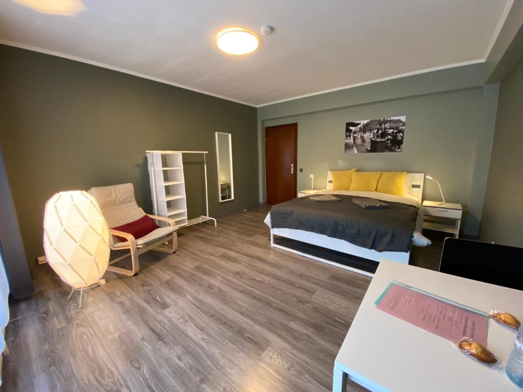 um quarto com uma cama, uma cadeira e uma mesa em Park City Center em Luxemburgo