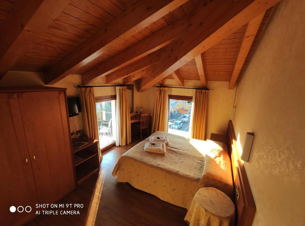sypialnia z łóżkiem i dużym oknem w obiekcie Azzano Holidays B&B w mieście Mezzegra