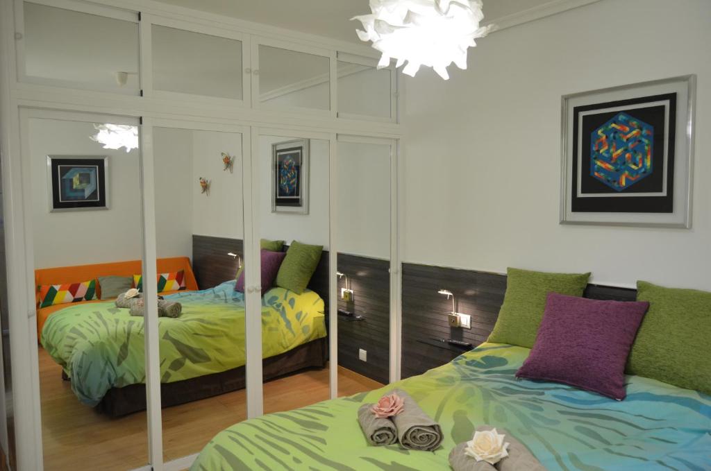 1 dormitorio con 2 camas y espejo en SEVILLA-TRIANA en Sevilla