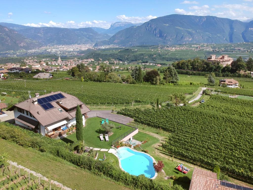  Elle offre une vue aérienne sur une villa située dans un vignoble et dotée d'une piscine. dans l'établissement Apartments Wolkan, à Appiano sulla Strada del Vino