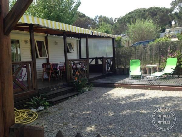 Mobilhome sur camping le kontiki **** ramatuelle في سانت تروبيز: منزل مع تراس مع كرسيين وطاولة