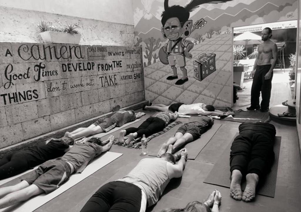 un grupo de personas tumbadas en el suelo en una clase de yoga en Arequipay Hostel en Arequipa