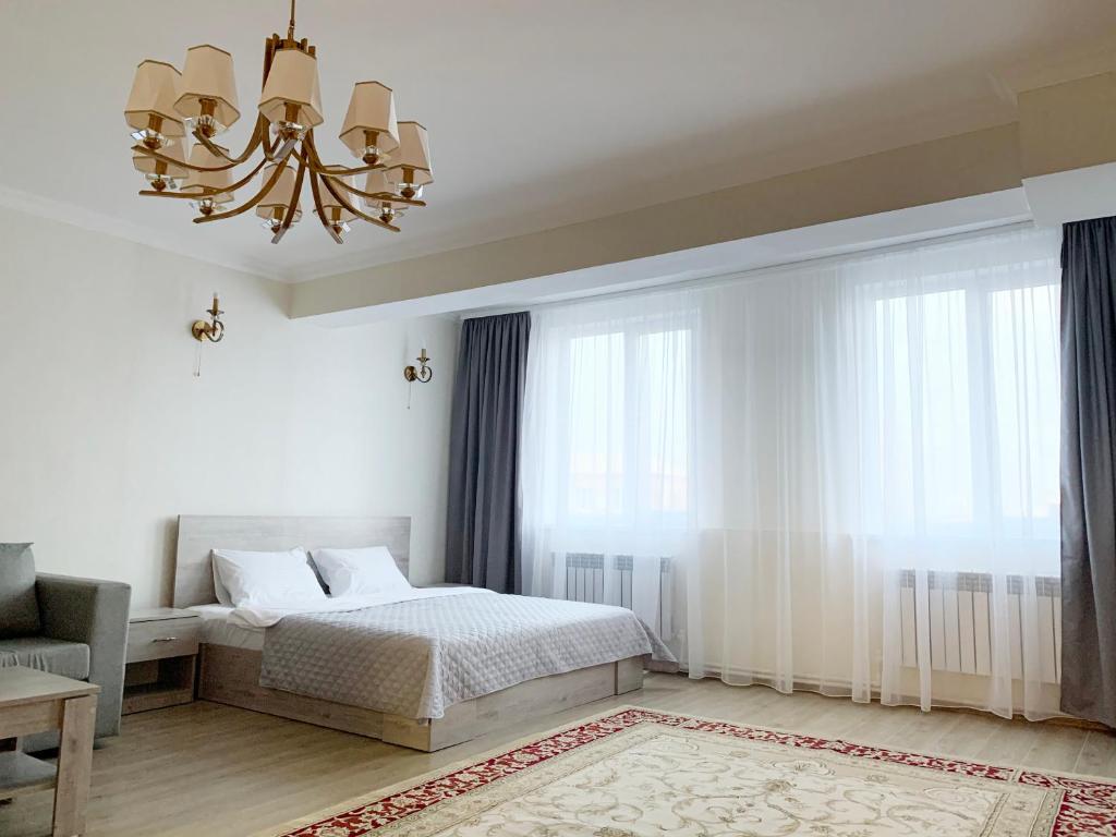 Un dormitorio con una cama y una lámpara de araña. en Brand new comfortable apartments in Sevan city, en Sevan