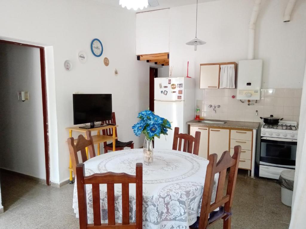 una cocina con una mesa con un jarrón de flores. en Buenas Vibras en Villa Carlos Paz