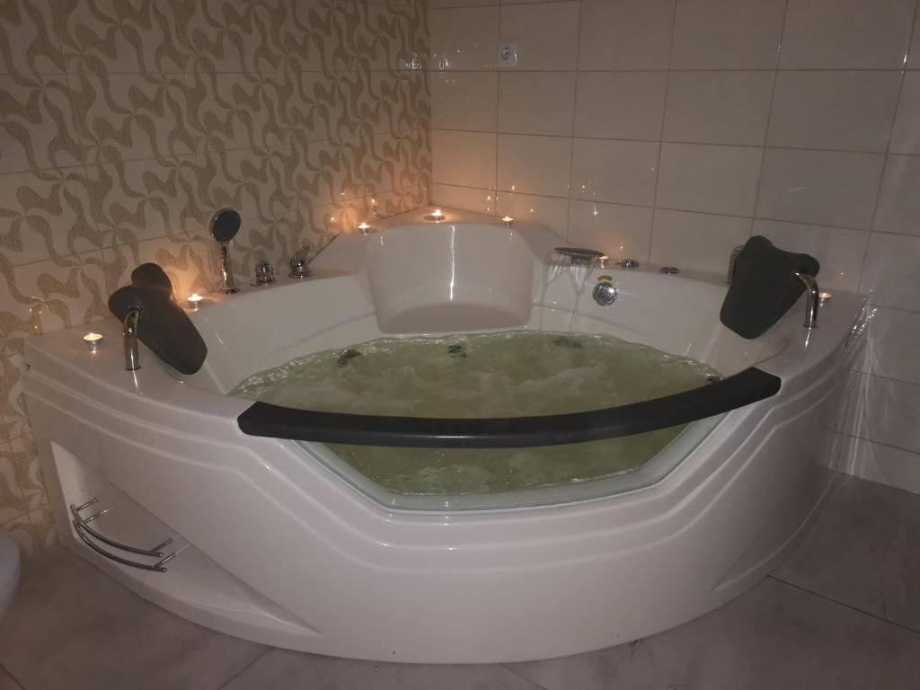 a white bath tub with lights in a bathroom at Apartamentai Rimkuose in Klaipėda