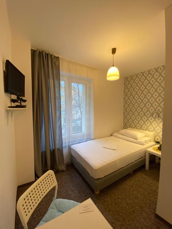 a hotel room with a bed and a window at Pastel Guest Rooms in Warsaw