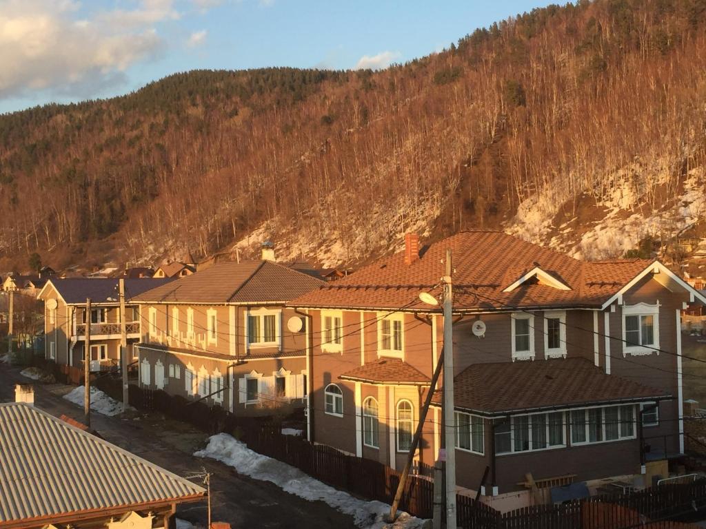 una fila de casas frente a una montaña en Usadba Demidova, en Listvyanka