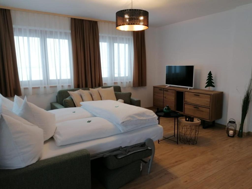 un soggiorno con un divano e una televisione di Studler Hofchalets a Oberperfuss