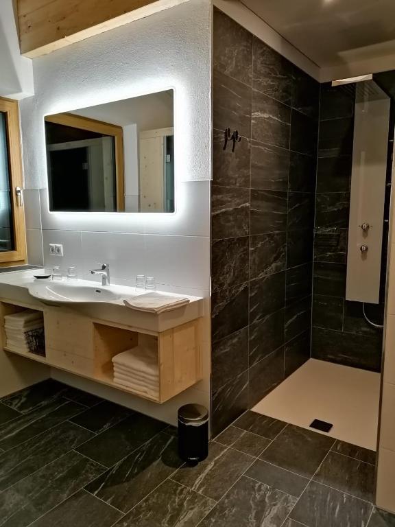 un bagno con lavandino e specchio di Studler Hofchalets a Oberperfuss