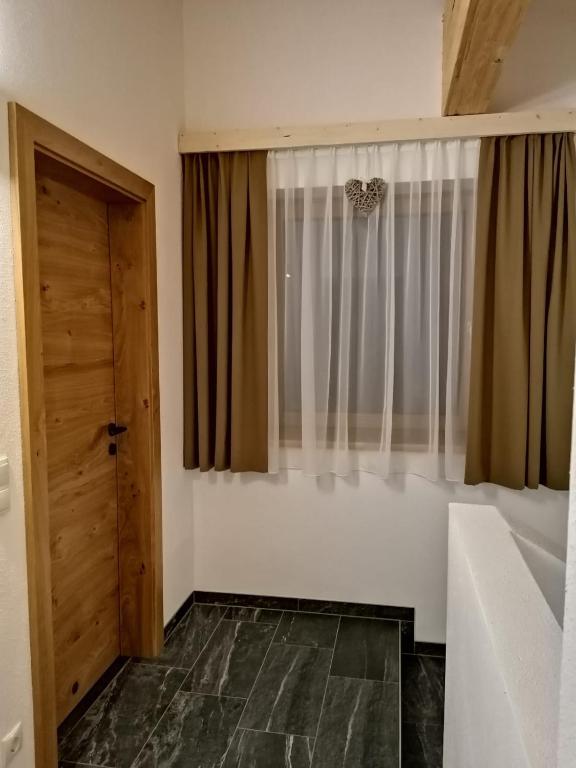 bagno con finestra, lavandino e vasca di Studler Hofchalets a Oberperfuss