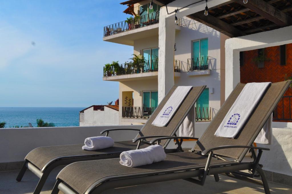 two lounge chairs on the balcony of a building at Petit Hotel Pilitas in Puerto Vallarta