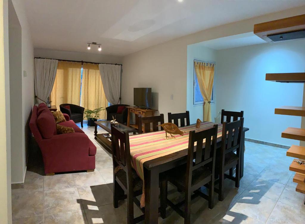 comedor con mesa y sofá rojo en Edificio Sam Slick, en El Calafate