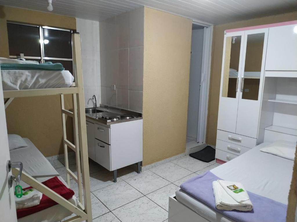 a room with two bunk beds and a kitchen at Hostel Aprisco São Paulo in Sao Paulo