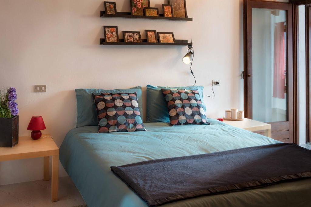 a bedroom with a bed with blue sheets and pillows at Hiking Escape Parzanica in Parzanica