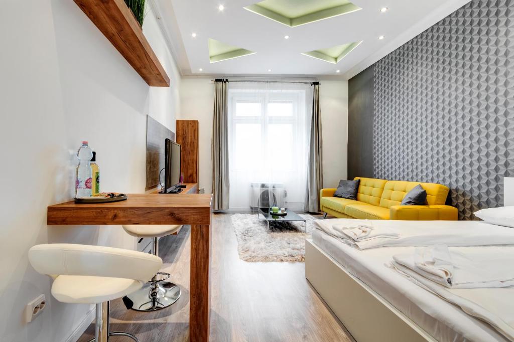 a bedroom with a bed and a yellow couch at Diamond Residence - Marble Apartment in Budapest