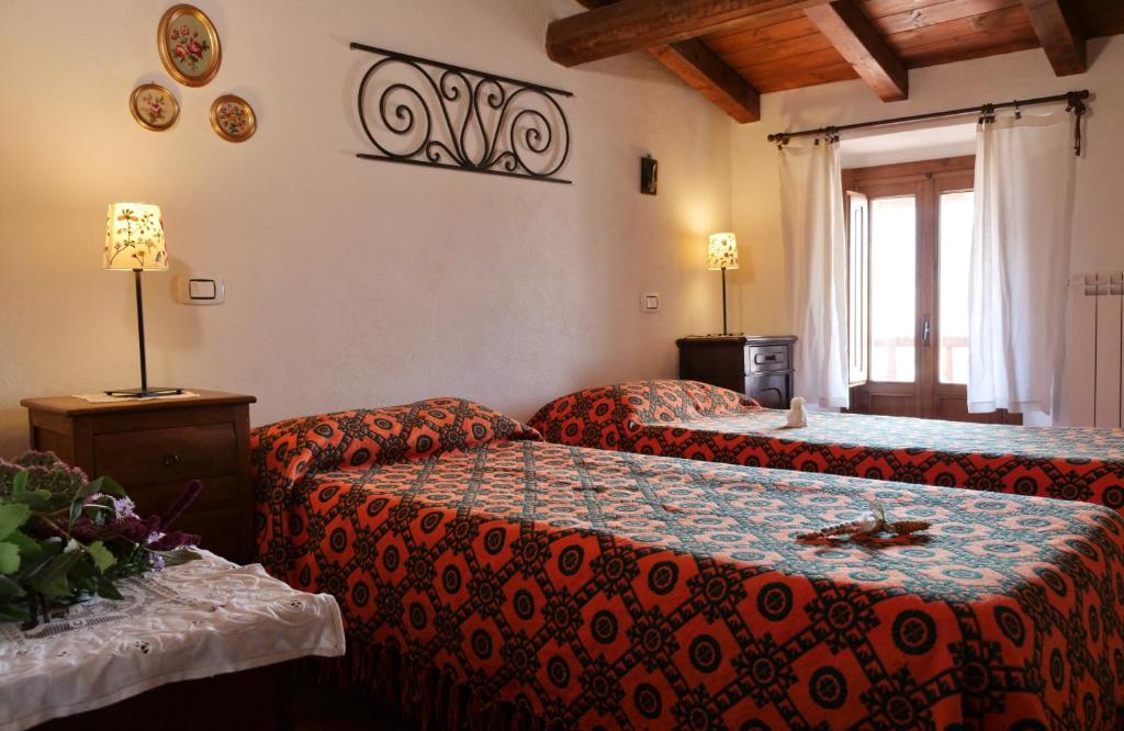 una camera d'albergo con due letti e un divano di Alle Vecchie Querce a Fontecchio