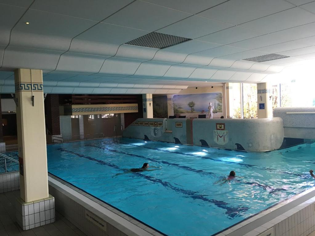 two people swimming in a large swimming pool at Ferienwohnung Reinhold im Predigtstuhl Resort in Sankt Englmar