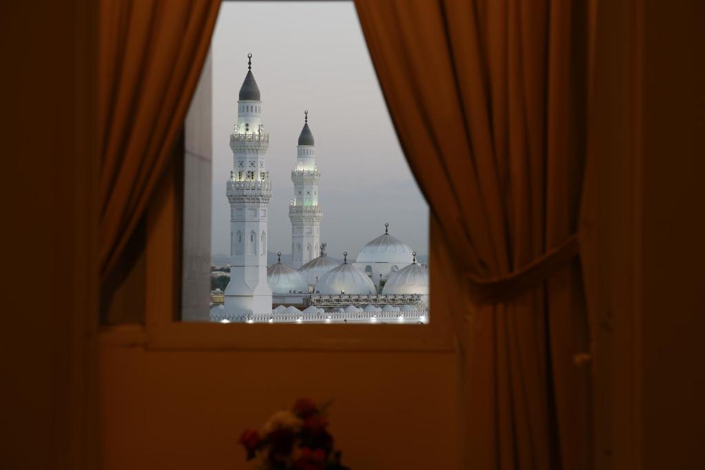 een uitzicht op een moskee door een raam bij ريف قباء للشقق الفندقيه in Al Madinah