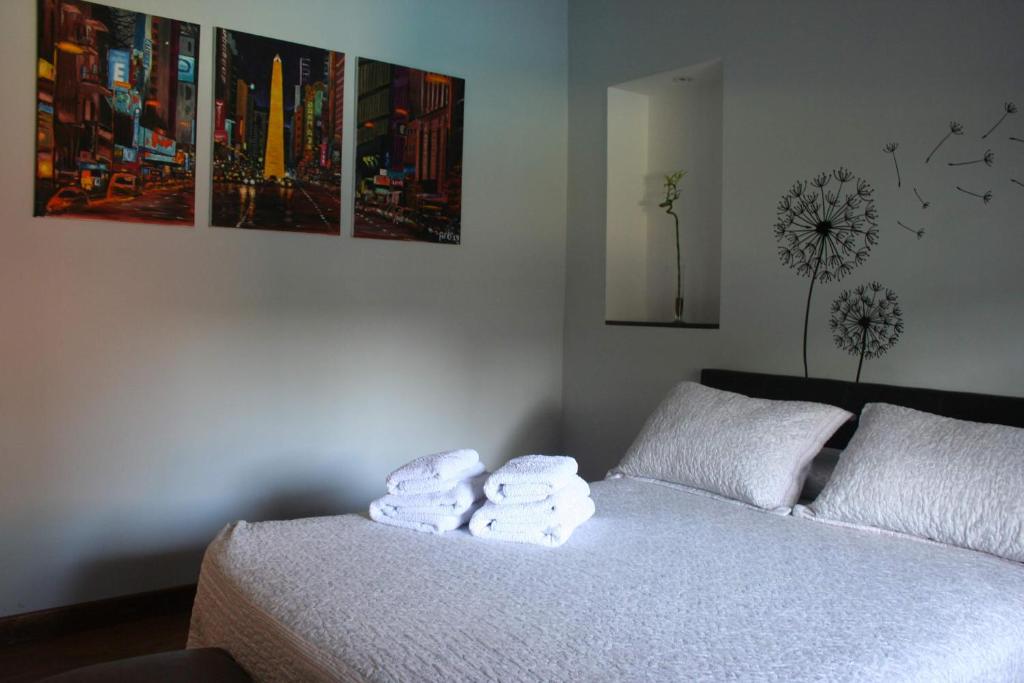1 dormitorio con 1 cama con toallas en TuHabitat BA en Villa Adelina