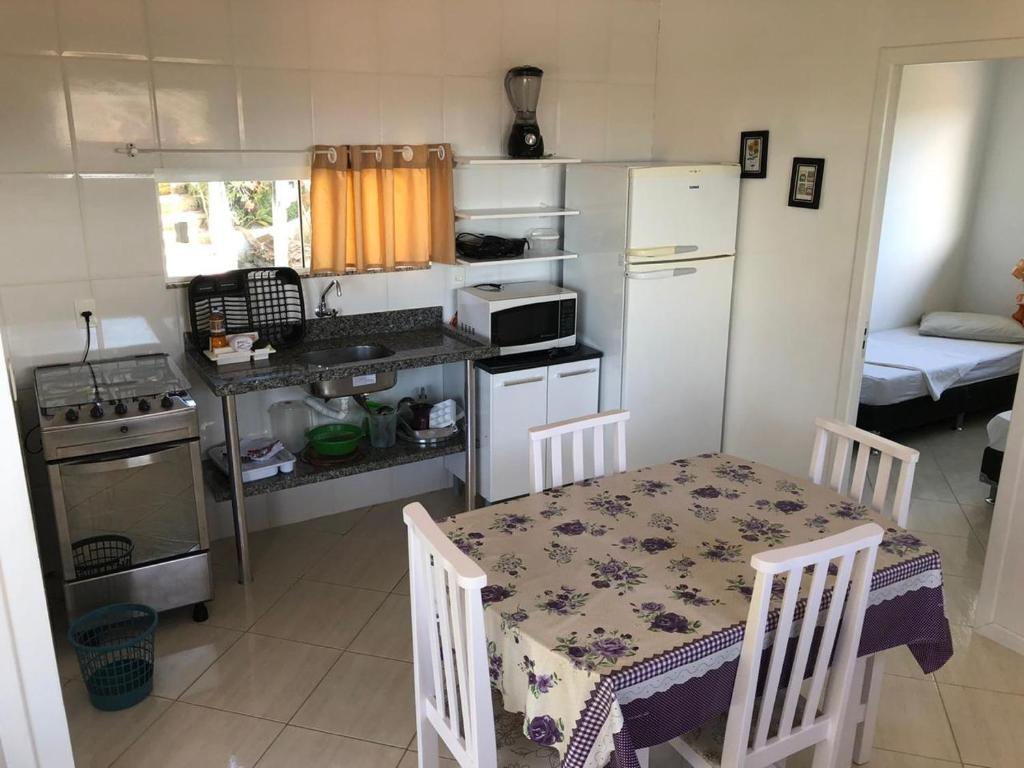 a small kitchen with a table and a refrigerator at Casa Canal Barra da Lagoa in Florianópolis