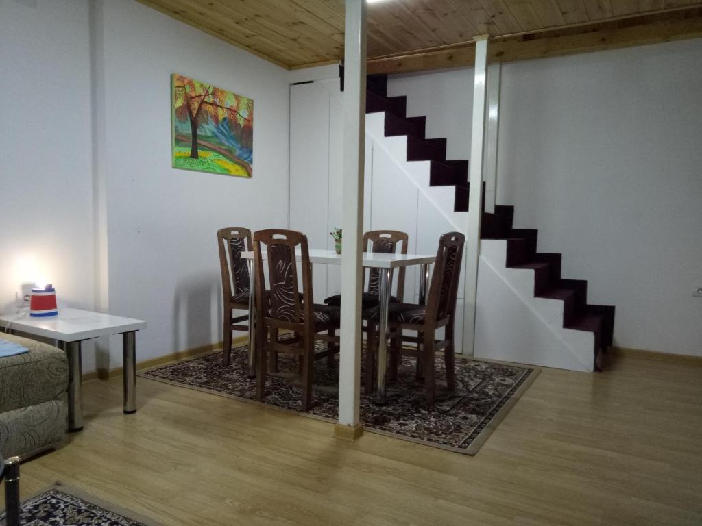 ein Esszimmer mit einem Tisch, Stühlen und einer Treppe in der Unterkunft Tiki Apartmen in Belgrad