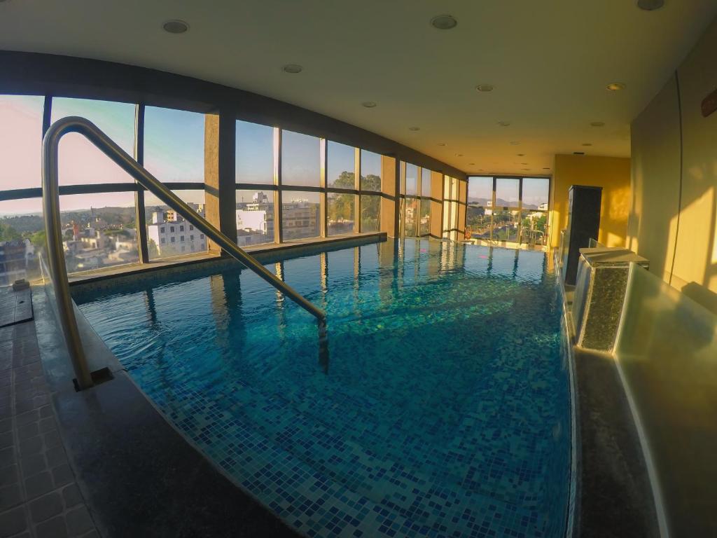 una gran piscina en un edificio con ventanas en Ananque Hotel & Spa en Villa Carlos Paz