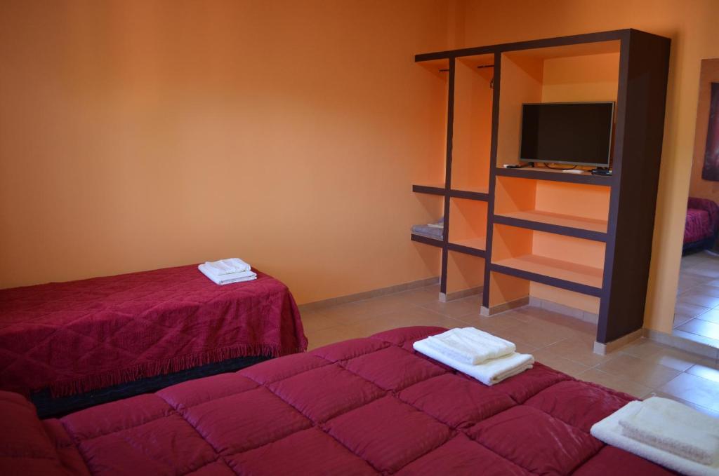 a room with two beds and a tv in it at Suyana Departamentos in Tinogasta