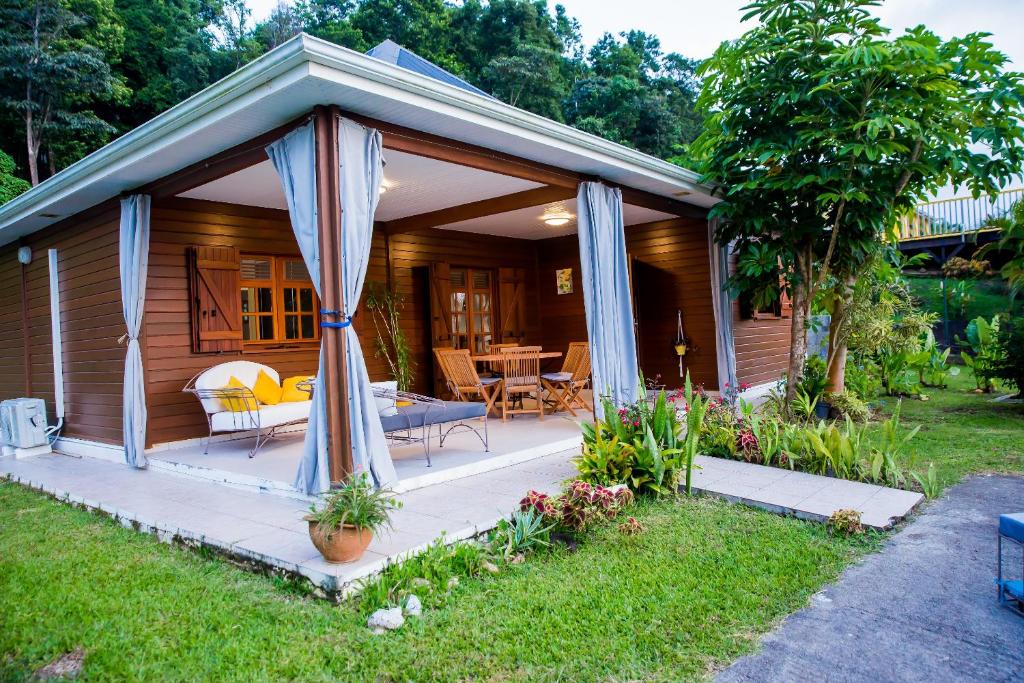 a gazebo with a table and chairs in a yard at Villa A rabica - Extrait de Café in Pointe-Noire