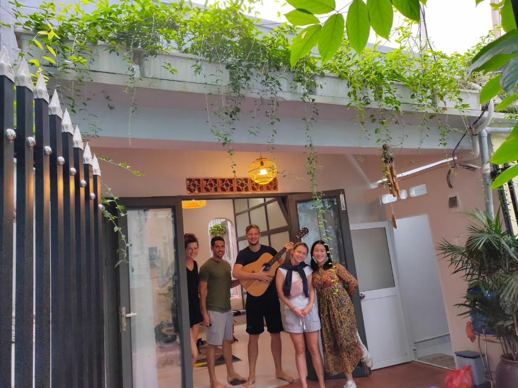 um grupo de pessoas em pé na frente de uma porta em The Quy Nhon Beach House with a Garden em Quy Nhon