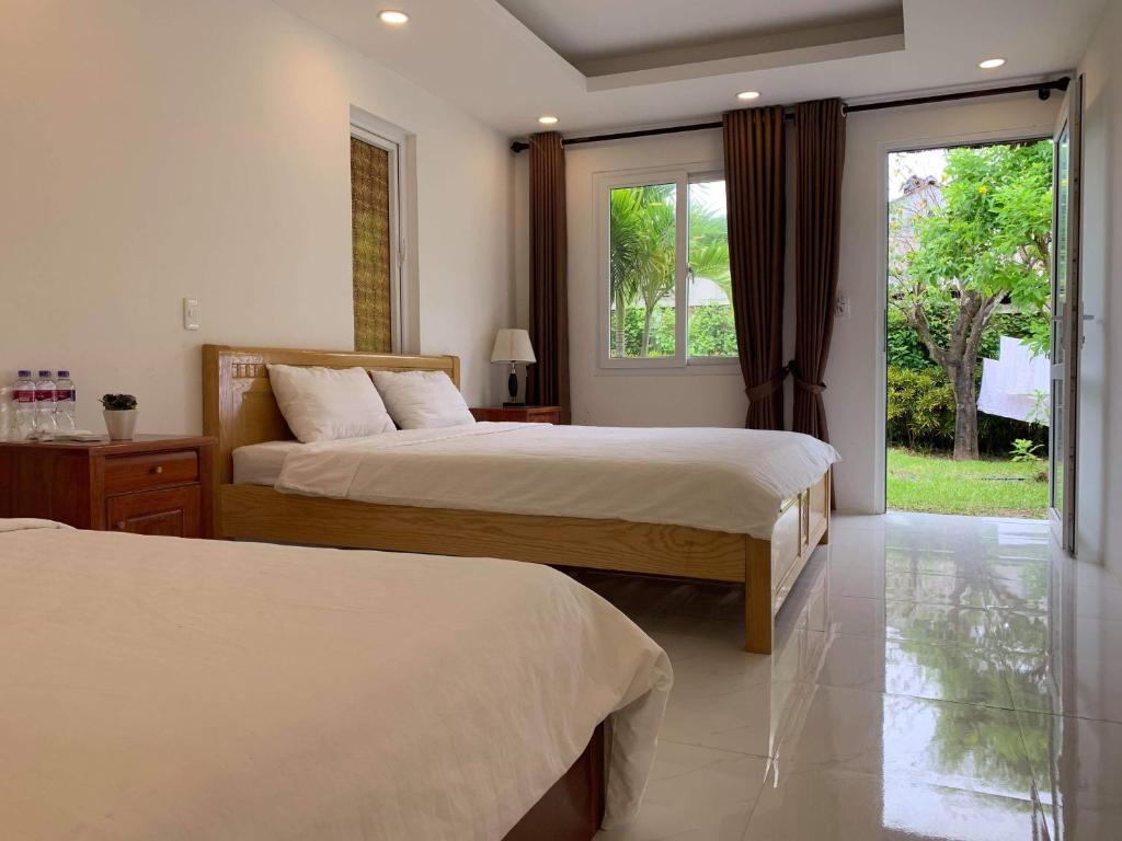 a hotel room with two beds and a window at Làng biển Homestay in Quang Ngai