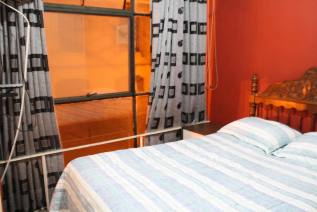 um quarto com uma cama e uma janela em Main Square em Lima