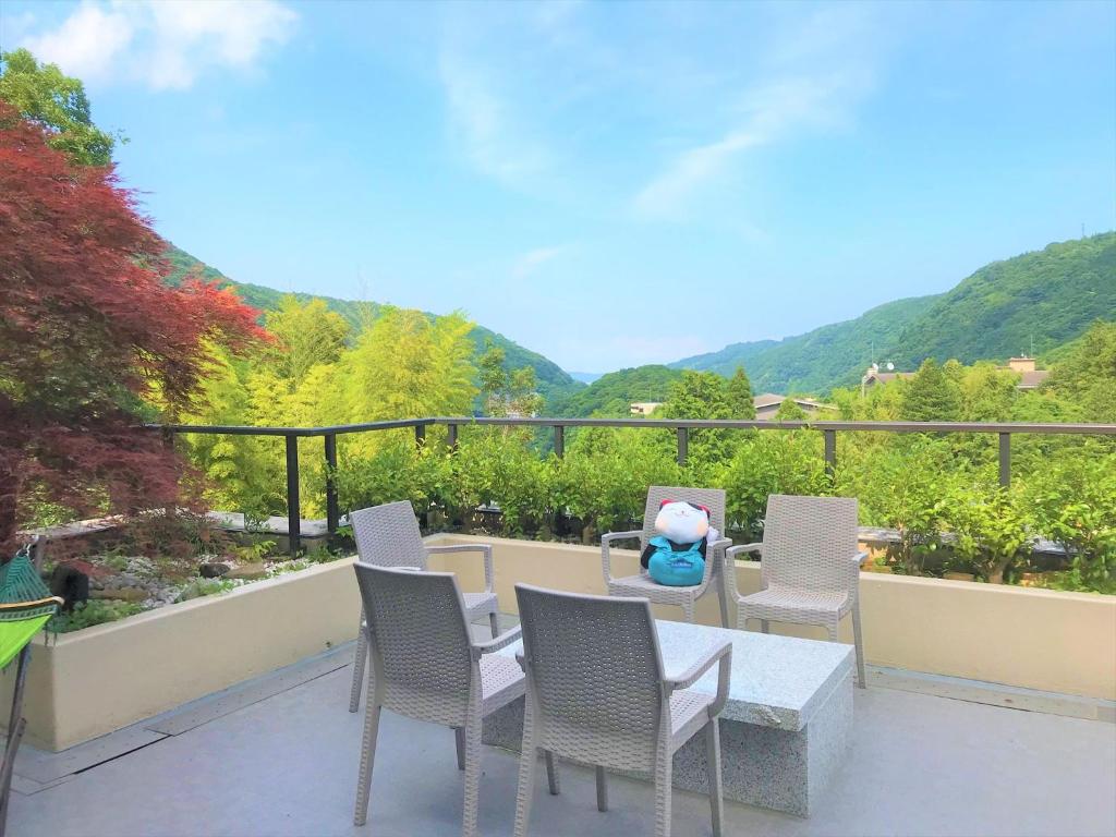 eine Terrasse mit Stühlen und einem Tisch auf dem Balkon in der Unterkunft K's House Hostels - Hakone Yumoto Onsen in Hakone