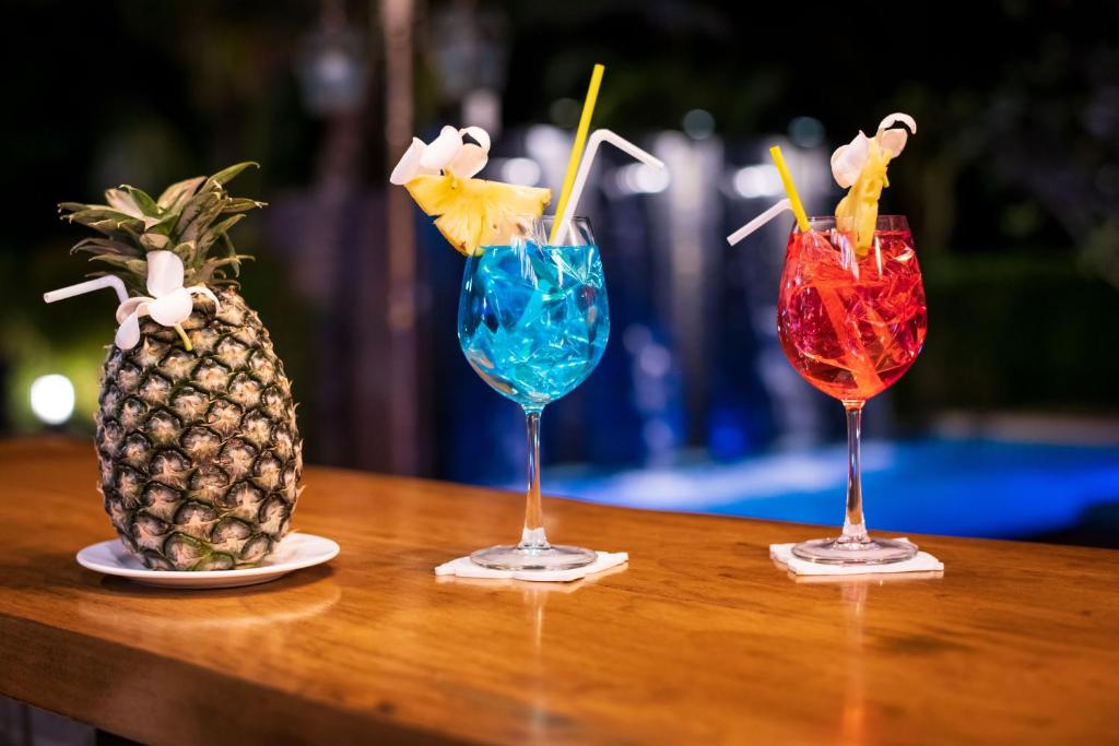 three cocktails on a table next to a pineapple at River Front Krabi Hotel in Krabi