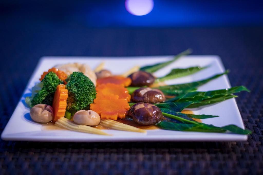 a plate of food with vegetables on a table at River Front Krabi Hotel in Krabi