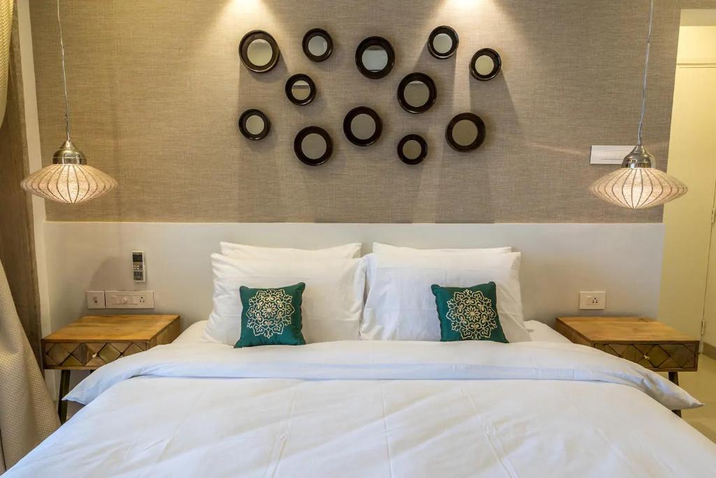 ein Schlafzimmer mit einem großen weißen Bett mit zwei Tischen in der Unterkunft Families & Corporates 3-Bed Apt, Fashion Res, Pune in Pune