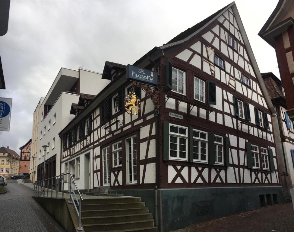 um edifício preto e branco com um relógio em Hotel Löwen em Lahr