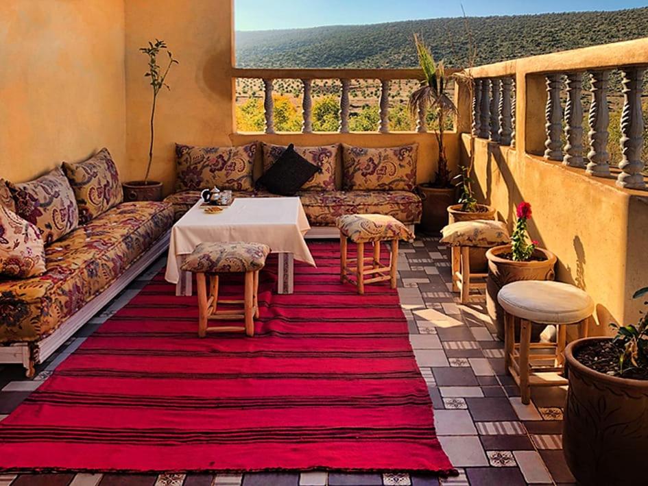 a living room with a couch and a table and chairs at Le petit Jardin in Demnat