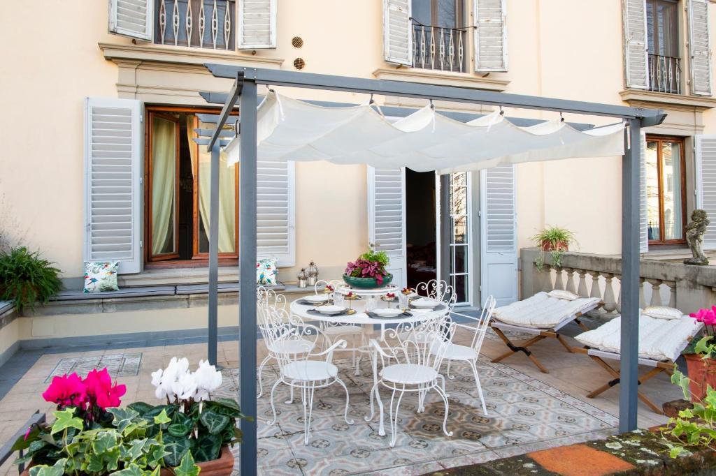 a patio with a table and chairs under a canopy at Contemporary Suites in Florence