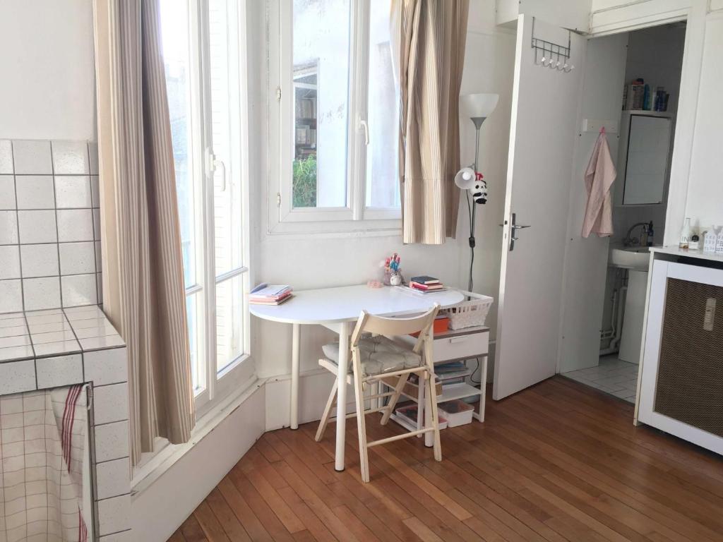 une petite cuisine avec une table blanche et une fenêtre dans l'établissement Best located flat in Saint-Germain-des-Prés, à Paris