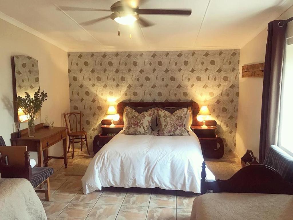 a bedroom with a bed and two tables and two lamps at Die Buitekamer in Bredasdorp