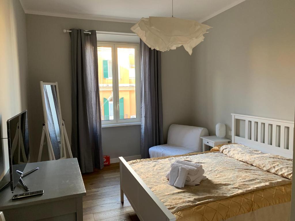 um quarto com uma cama, uma secretária e uma janela em La Casetta del Flaminio em Roma