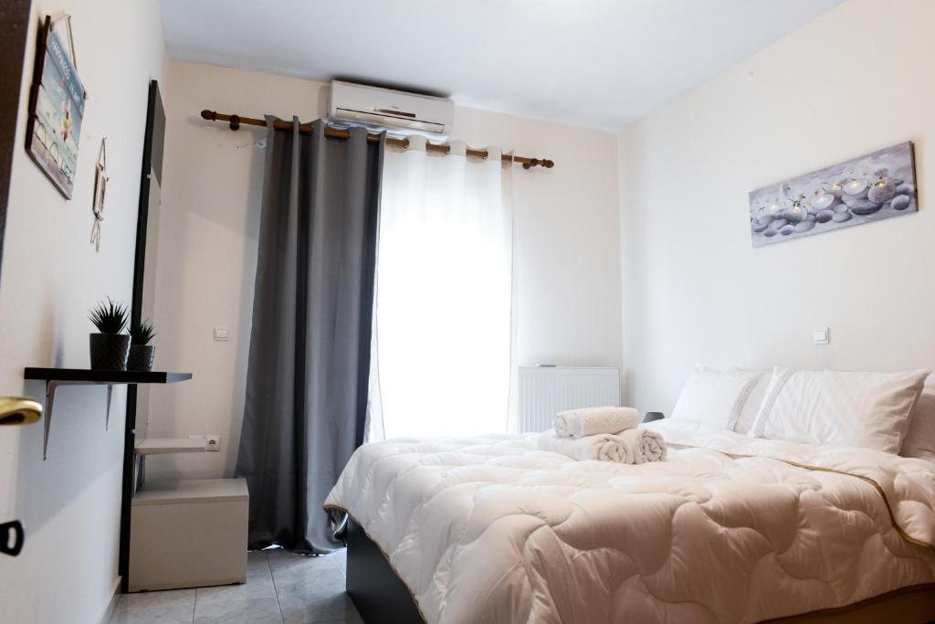 Un dormitorio con una cama grande y una ventana en Papi's Free Parking Apartments 2 - 2 Bedroom en Alejandrópolis