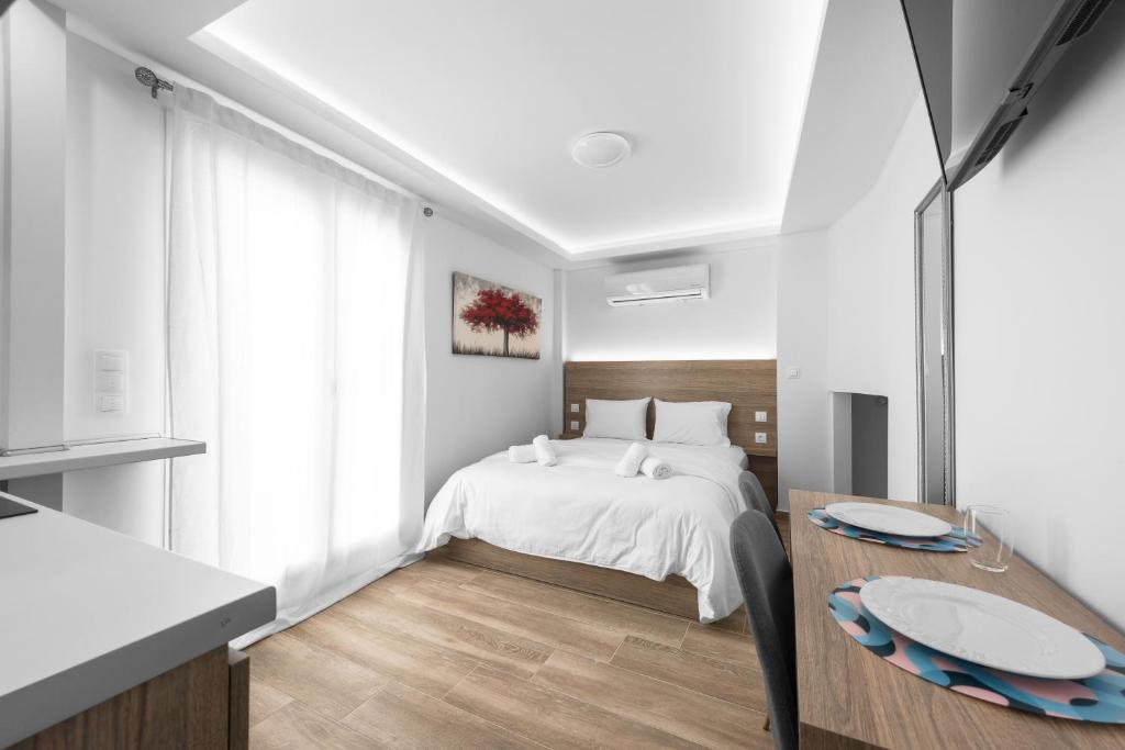 ein weißes Schlafzimmer mit einem Bett und einem Tisch in der Unterkunft Penthouse Level 9, Nilie Hospitality MGMT in Thessaloniki
