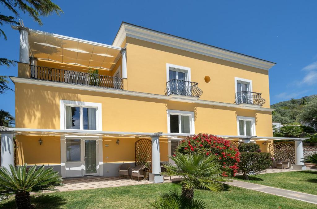 a large yellow house with a yard at Hotel Villa Ceselle in Anacapri