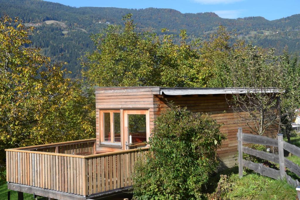 a cabin in the woods with a porch and a window at Tiny Häuschen in Ossiach