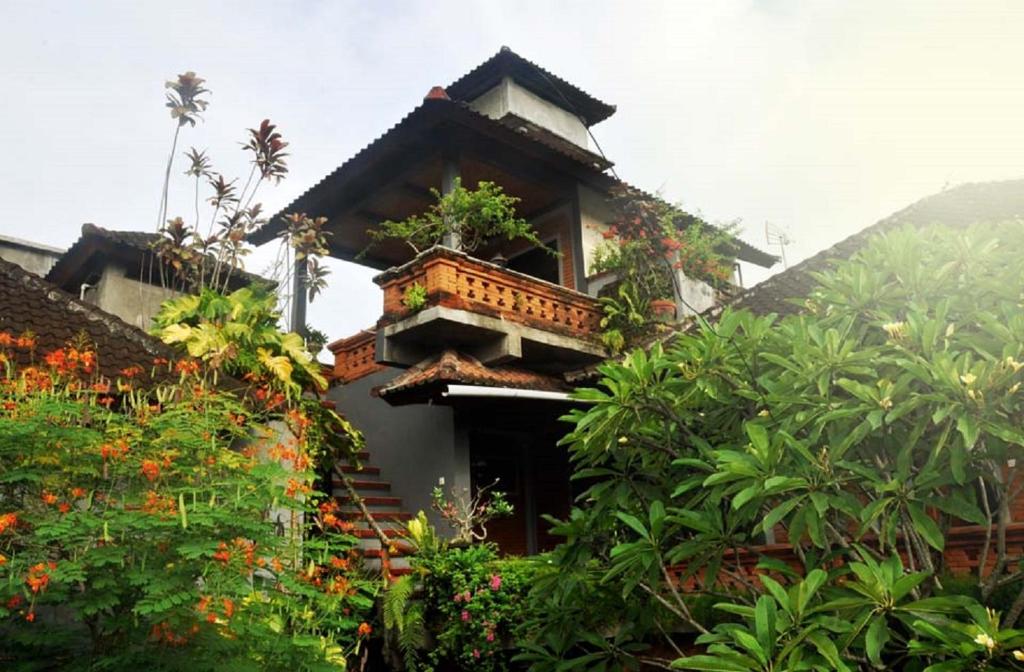 ein Gebäude mit einem Balkon mit Pflanzen in der Unterkunft Candra Asri Bungalow in Ubud