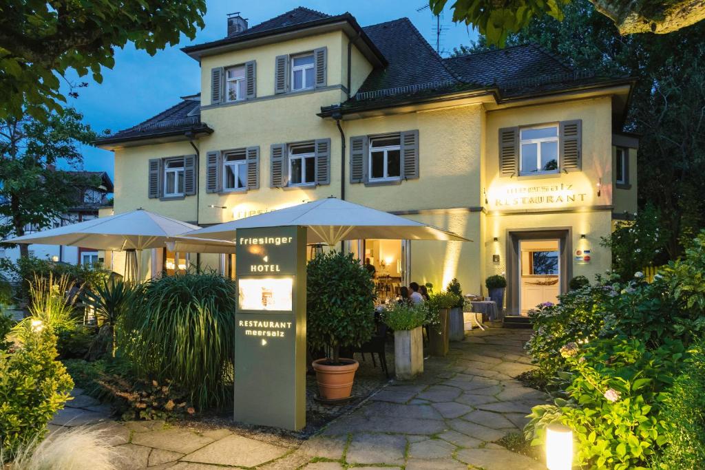 un edificio con ombrelloni di fronte di Boutique Hotel Friesinger a Kressbronn am Bodensee